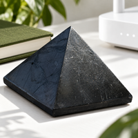 Close-up of a shungite pyramid next to a router