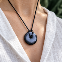 Small shungite torus pendant worn, close-up