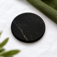 A single 20 mm shungite phone sticker on linen
