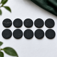 Ten 20 mm shungite phone stickers laid out in rows