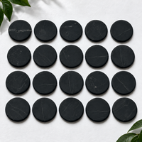 Twenty 20 mm shungite phone stickers laid out in rows