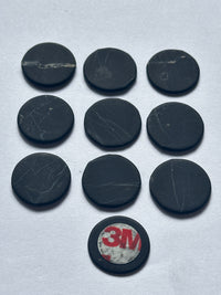 Ten shungite phone stickers, one turned to show the 3M adhesive back