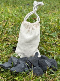 Cotton bag of raw shungite water stones on grass, 330 g