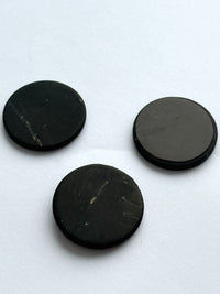 Three shungite phone stickers on white