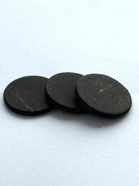 Three shungite phone stickers laid overlapping on white