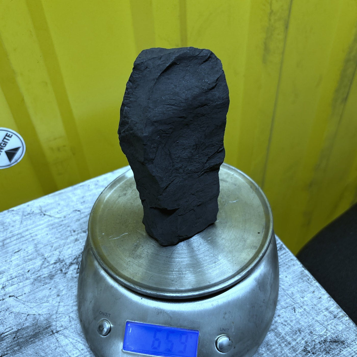 Raw shungite specimen 012, 659 g, on the scale showing its weight